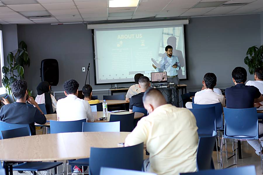 Attendees watching a presentation on the About Us slide