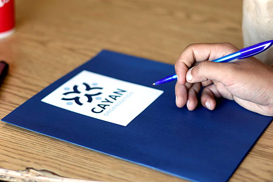 A Cayan folder with the logo on a table